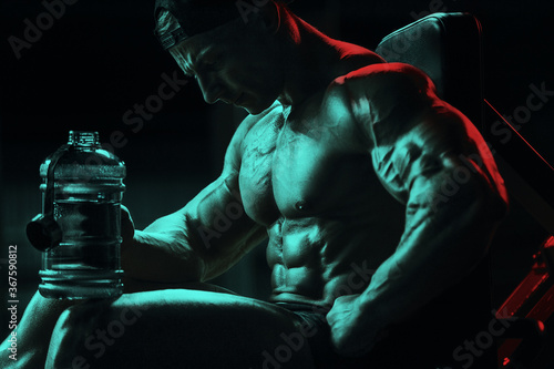 Bodybuilder with protein powder supplements jar