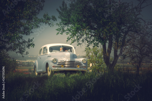 Front view of an old classic car on the street. Retro style photo of an american oldtimer from the 1940s. Vintage USA vehicle on a sunny summer day. Oldschool travel, traffic concept