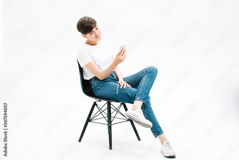 young woman sitting on a ​chair and using phone