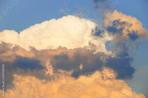 Clouds and sky. A large thundercloud against blue sky at sunset.