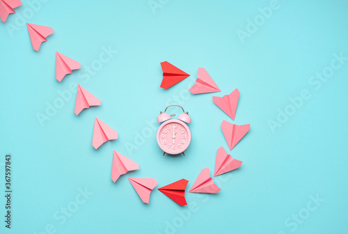 Time management concept with a clock and paper airplanes. Time flies concept, top view photo