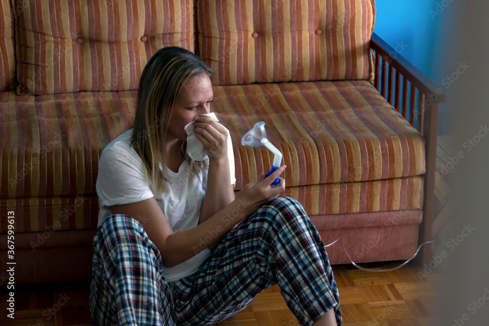 Women inhalation therapy with mask of inhaler with soft stream smoke from asthma inhaler.Shot of