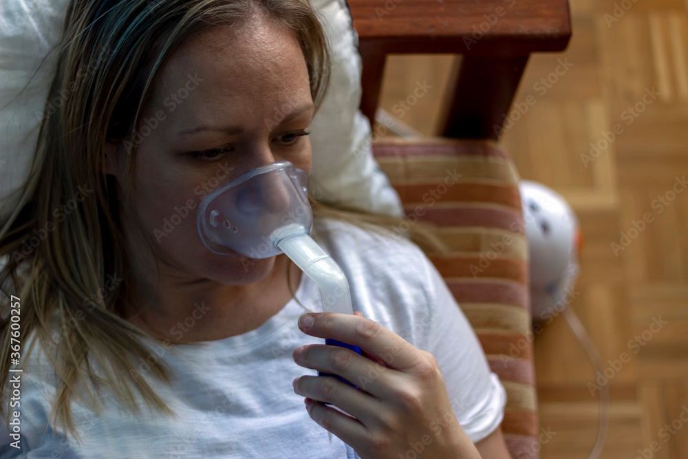 Woman's face inhaling through inhaler mask.Female patient inhalation therapy with mask of