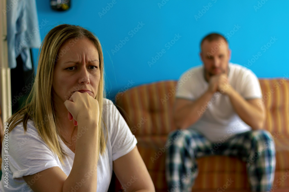 Image of an unhappy young couple having relationship problems crisis.Sad pensive young women thinking of relationship problems,sitting on sofa with offended boyfriend,conflicts in marriage.Copy space.