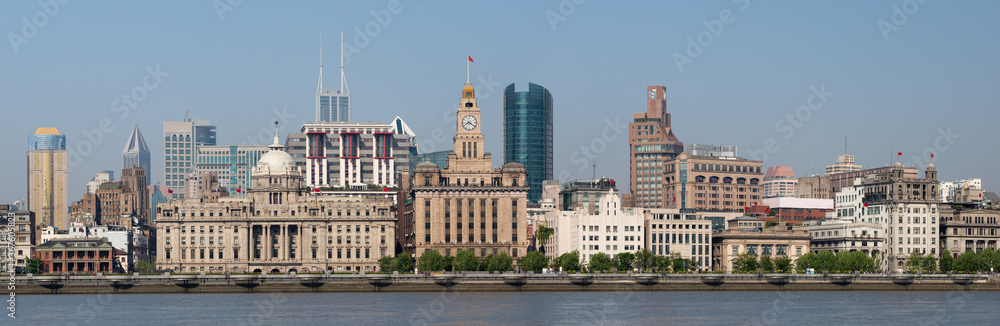 Shanghai, China - April 19, 2018: Panorama of historical buildings at the Bund (Waitan). With HSBC building and Customs House. Huanpu River in the foreground.