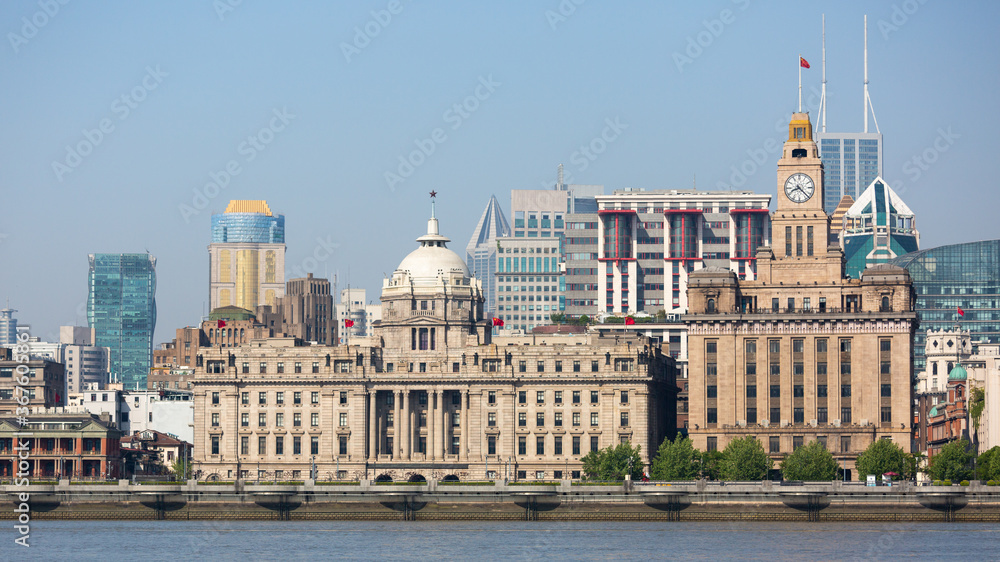 Shanghai, China - April 19, 2018: Front view of HSBC building and Customs House at the Bund (Waitan). Huangpu River in the foreground.