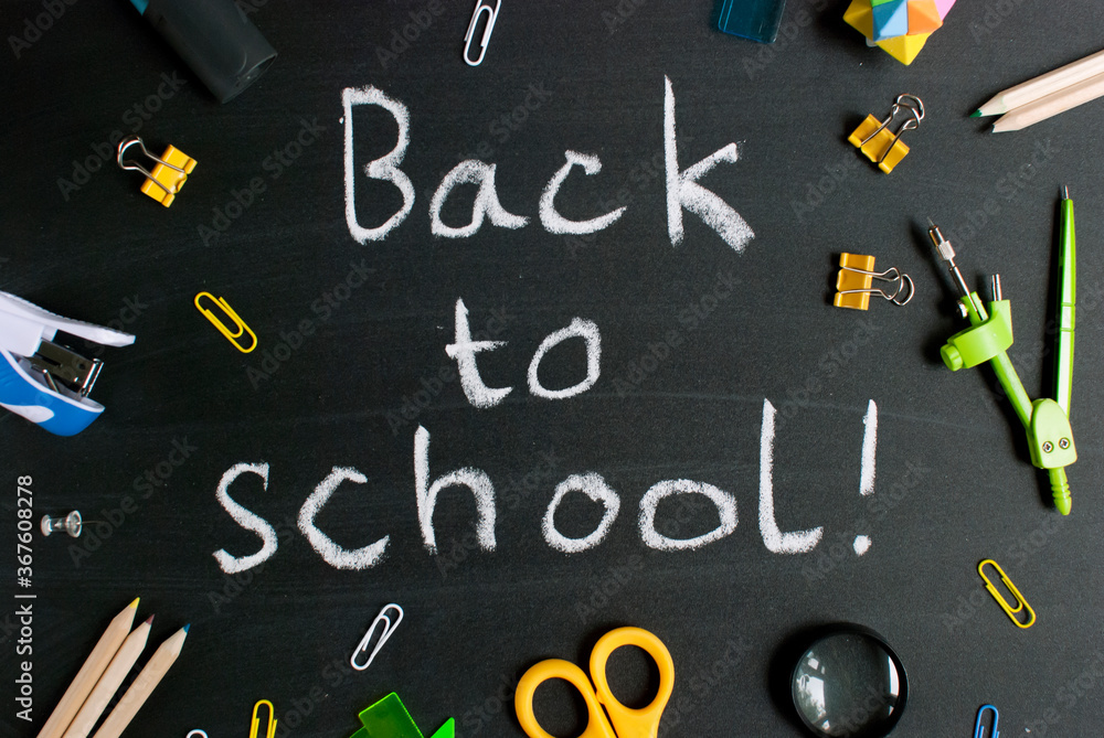 Inscription back to school. On a chalky black board. Handwritten. Stationery school accessories. Inscription back to school. On a chalky black board. Handwritten. Stationery school accessories.