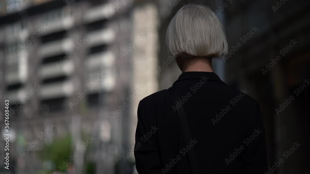 young transgender person is walking in city, camera is following his, blond man is turning young transgender person is walking in city, camera is following his, blond man is turning