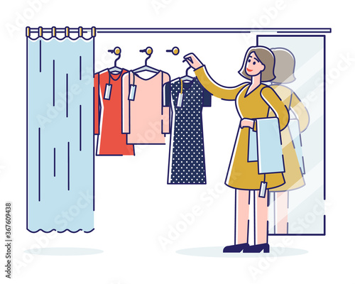 Woman on shopping choosing clothes on hangers for trying in dressing room