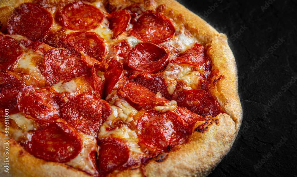 Pepperoni Pizza with Mozzarella cheese, salami, Tomato sauce, pepper, Spices. Italian pizza on Dark grey black slate background Pepperoni Pizza with Mozzarella cheese, salami, Tomato sauce, pepper, Spices. Italian pizza on Dark grey black slate background