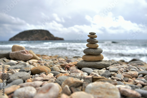 una torre de piedras redondas en una playa del mediterraneo