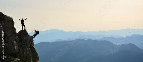 Fotografie Crazy climbers doing rock climbing in the sunset