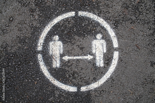 Social distancing sign on pavement.