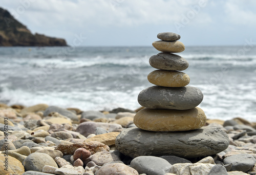 una torre de piedras redondas en una playa del mediterraneo