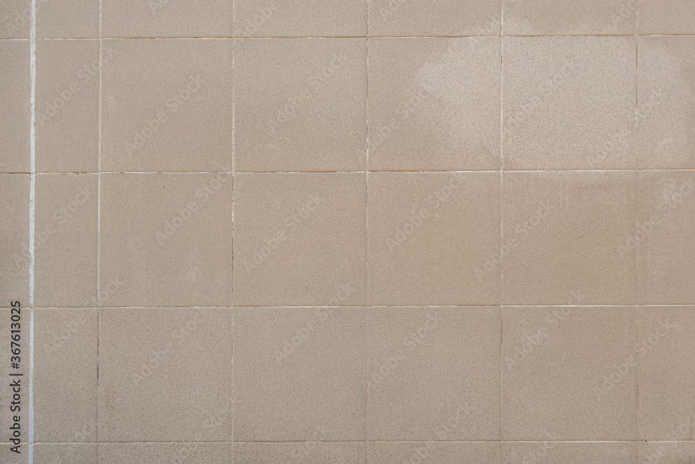 Fototapeta premium abstract background of an old beige ceramic tiles close up