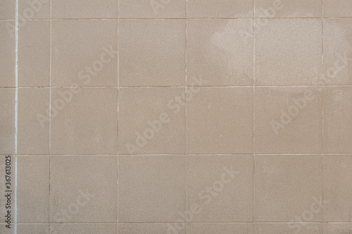 abstract background of an old beige ceramic tiles close up
