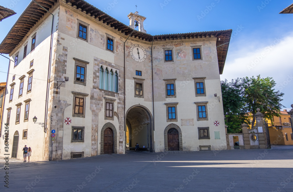 Pisa, Italy - August 14, 2019: Palazzo dell'Orologio with the Arched Gate in the Knights Square or Piazza dei Cavalieri in Pisa, Tuscany, Italy
