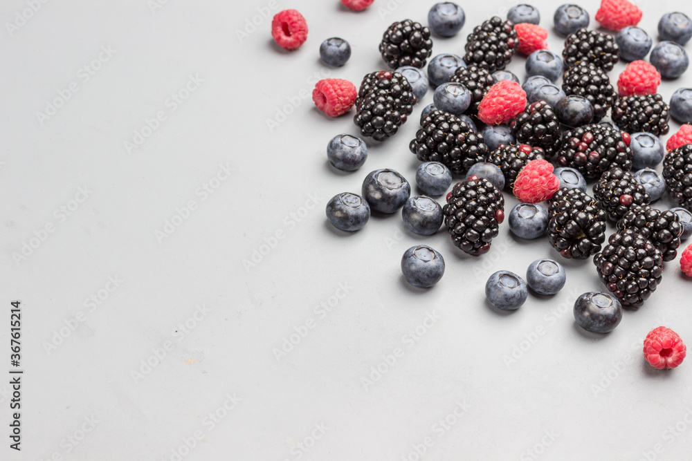 Blackberries, raspberries and blueberries on gray background. Blackberries, raspberries and blueberries on gray background.