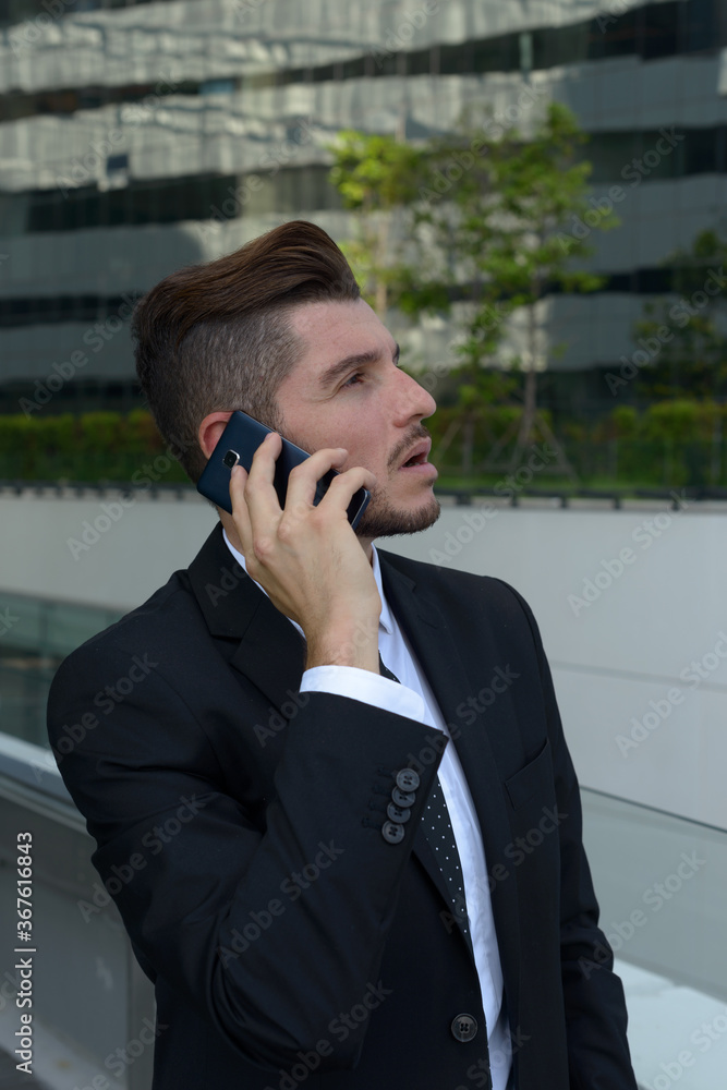 Handsome bearded Hispanic businessman against view of the city Handsome bearded Hispanic businessman against view of the city