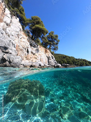 Sea level and underwater photo of caves and rocky nature in famous turquoise pebble beach of Kastani where famous Mamma Mia movie was filmed, Skopelos island, Sporades, Greece © aerial-drone