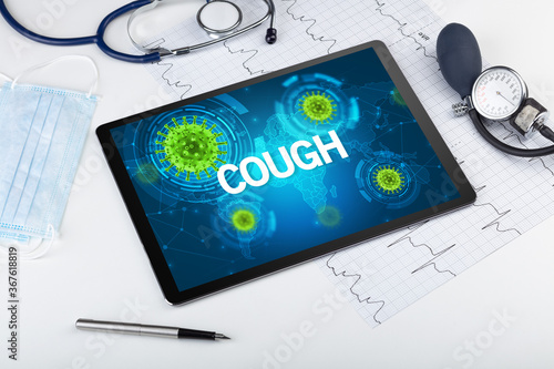 Close-up view of a tablet pc with COUGH inscription, microbiology concept