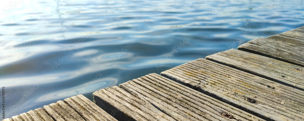piece of wooden pier and waves in the sea piece of wooden pier and waves in the sea