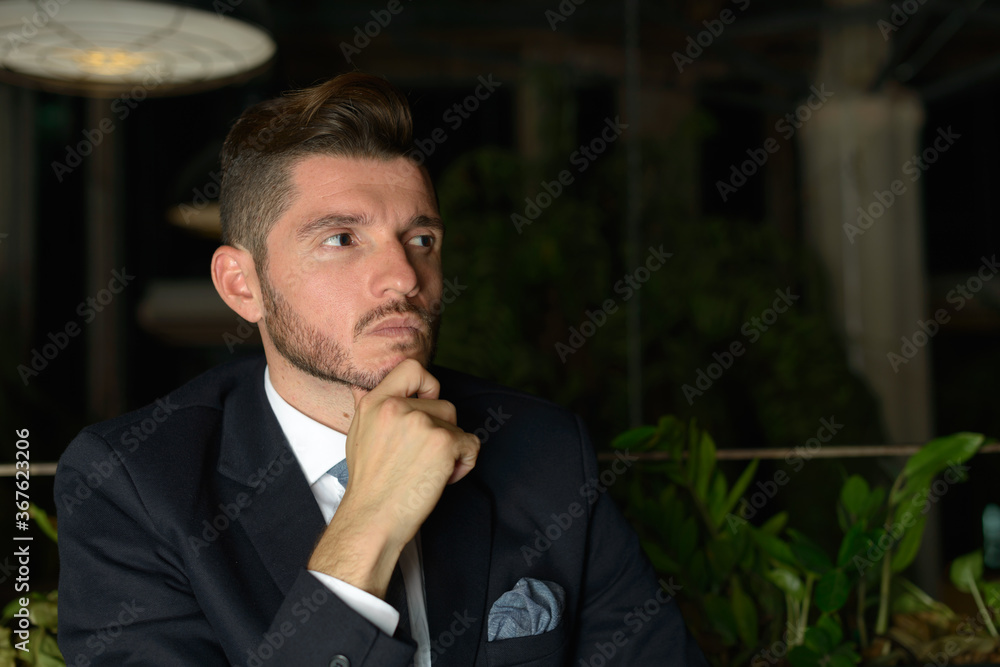 Handsome bearded Hispanic businessman relaxing at the coffee shop at night Handsome bearded Hispanic businessman relaxing at the coffee shop at night