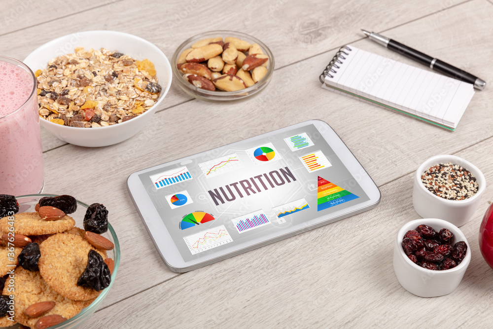 Organic food and tablet pc showing NUTRITION inscription, healthy nutrition composition Organic food and tablet pc showing NUTRITION inscription, healthy nutrition composition