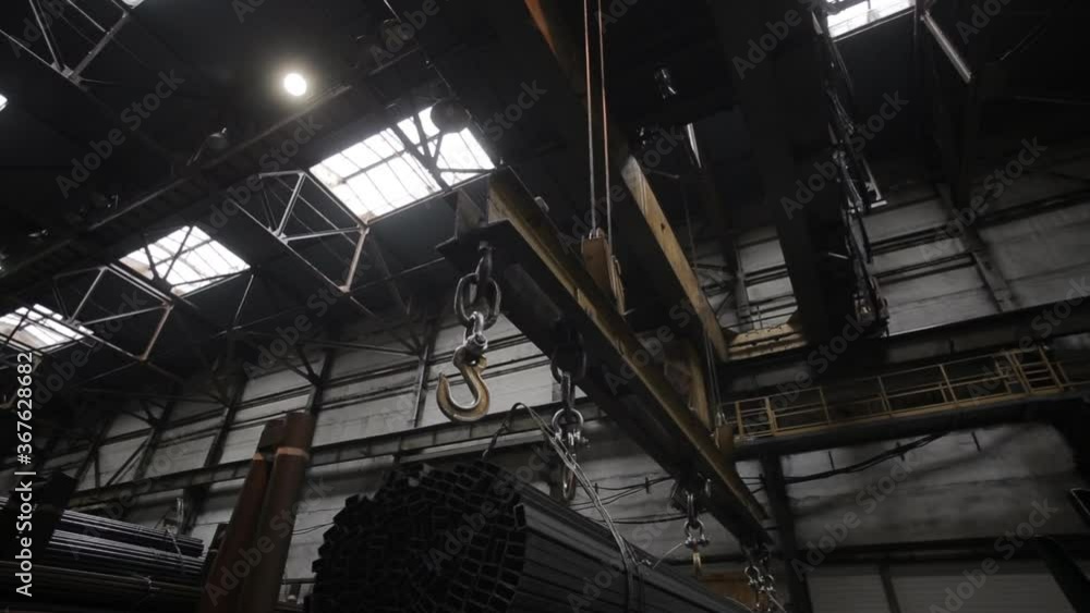 Metallurgical industry. Warehouses of finished products. An industrial crane carries pipes. Metallurgical industry. Warehouses of finished products. An industrial crane carries pipes.