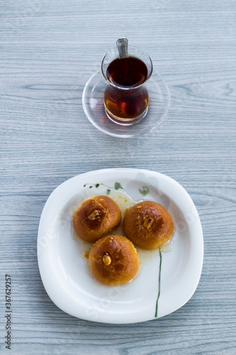 Traditional Turkish Baked Pastry, "Sekerpare" with cutlery set on the wooden table.Ramadan or Feast Desserts