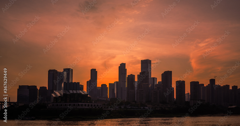 Silhouettes of buildings surrounded by the Yangtze river under the sunlight during the sunset in Chongqing