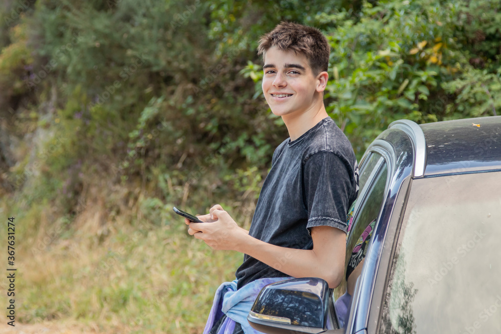 Obraz premium young boy with mobile phone and car outdoors