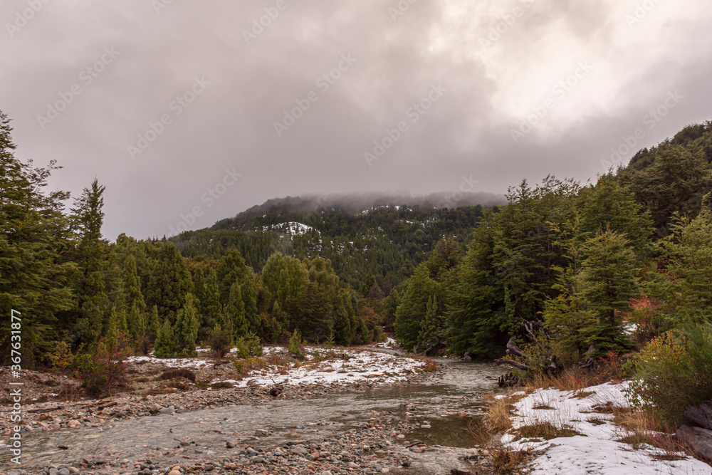Scene view of mountain landscape with clouds in Los Alerces National Park during winter season Scene view of mountain landscape with clouds in Los Alerces National Park during winter season