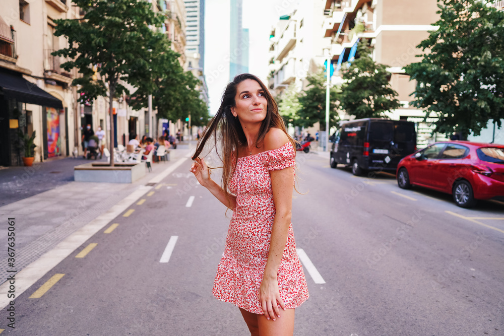 Beautiful young fashionable woman in sexy stylish dress posing in the city with standing on the road