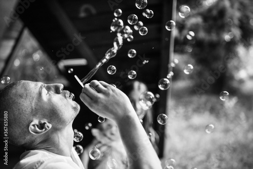 Portrait of caring father blow the bubbles for little daughter