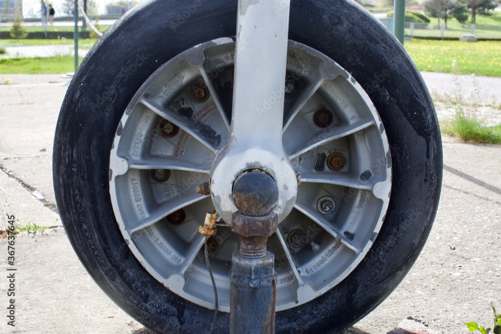 close up view the front wheel of an old airplane. landing gear.