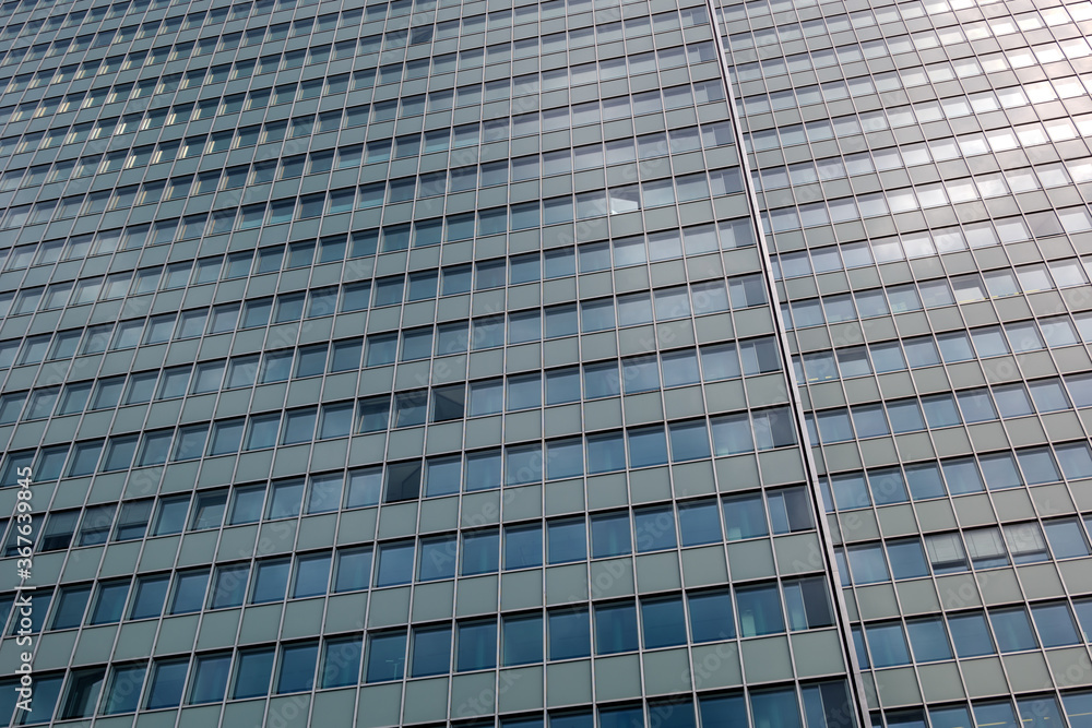 Close up detail of modern glass facade with rectangular windows frame system of office building against blue sky. Abstract Architectural Geometry elements with urban metropolis concept.