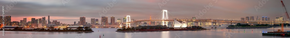 Tokyo Destinations. Famous Rainbow Bridge in Odaiba Island in Tokyo with Line of Skyscrapers in Background. Tokyo Destinations. Famous Rainbow Bridge in Odaiba Island in Tokyo with Line of Skyscrapers in Background.