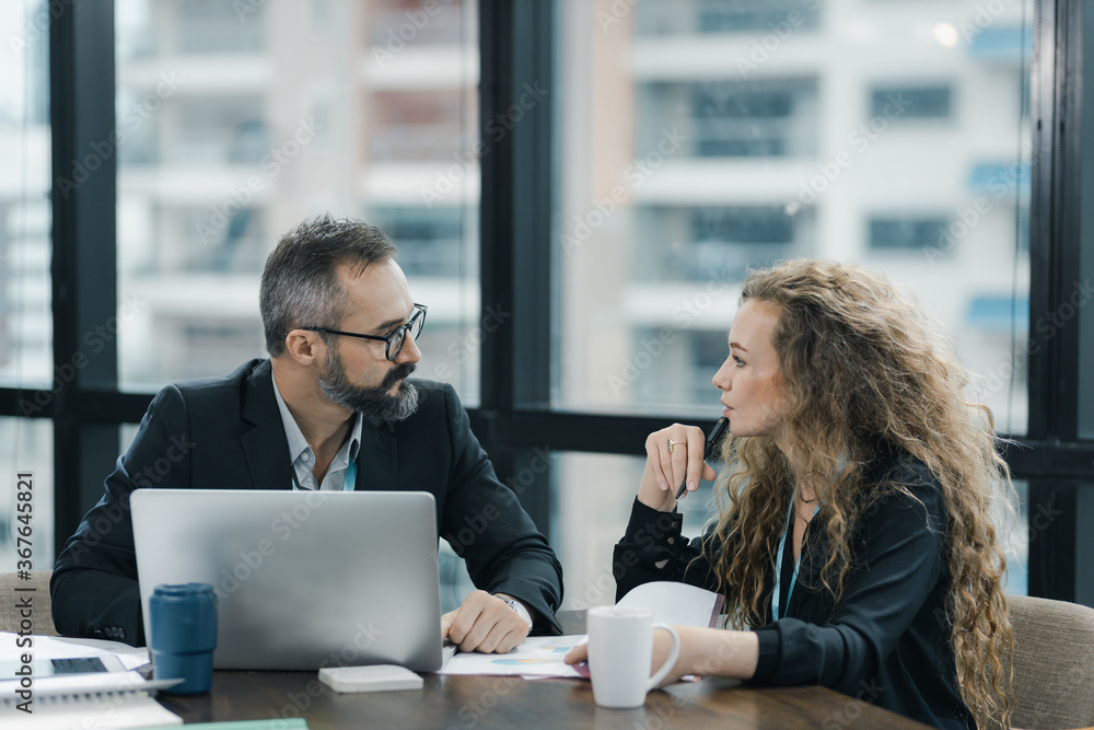 Obraz premium Young manager listening to his colleague explanations in modern co working office.