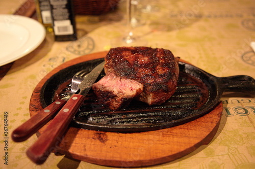 Grilled Argentina rib eye beef steak meat on table at a traditional Argentinean restaurant, in Buenos Aires, Argentina.