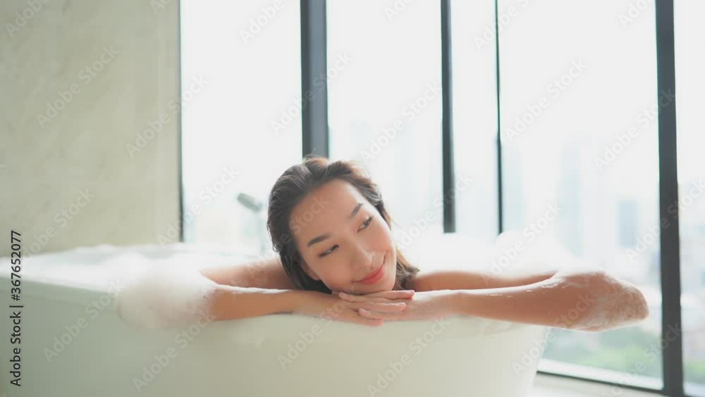 Satisfied asian woman enjoying a relaxing foam bath Satisfied asian woman enjoying a relaxing foam bath