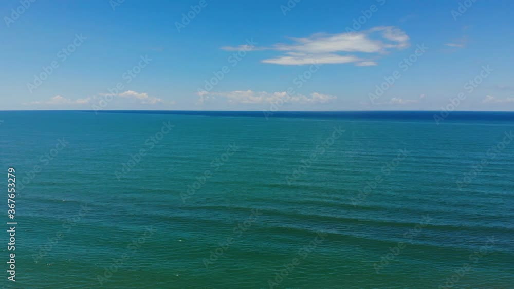 Blue turquoise sea texture with vibrant clean water under bright sky with white clouds Blue turquoise sea texture with vibrant clean water under bright sky with white clouds