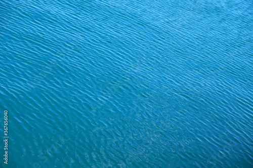 Ripples on blue water, diagonal perspective view, soft low contrast image.