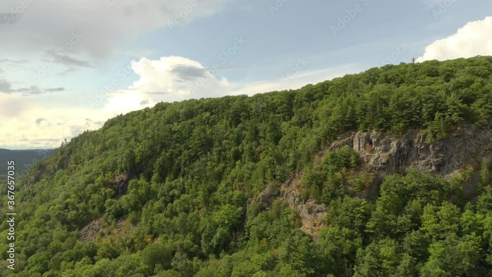 Drone lowering altitude and flying sideways showing natural mountain side Drone lowering altitude and flying sideways showing natural mountain side