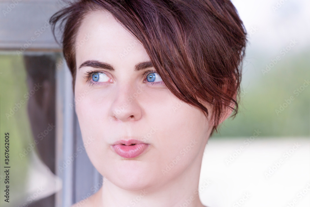 Naklejka premium Portrait of a girl with blue eyes, wide brown eyebrows and short hair