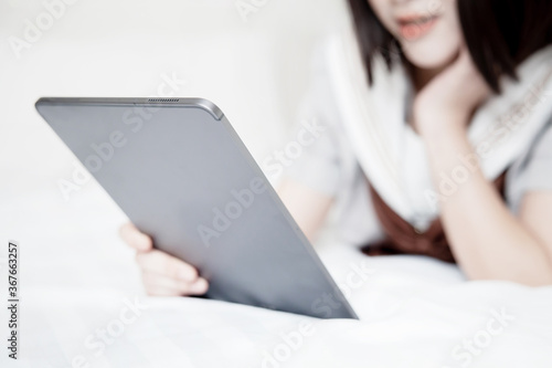 Woman Playing Tablet on Her Bed