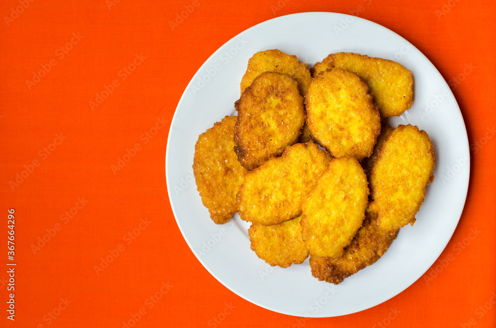 Panamanian style sweet corn fritters on orange background Panamanian style sweet corn fritters on orange background