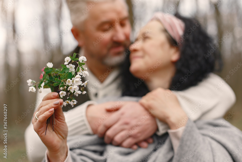 Fototapeta premium Seniors in a forest. People walks. Family with spring's flowers.