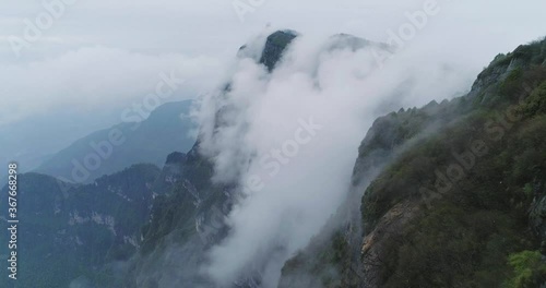 Aerial view of drone flying close to the cliff mist clouds floating in the forest 4k nature Emei mountain landscape UNESCO World Heritage site in Sichuan China  photo