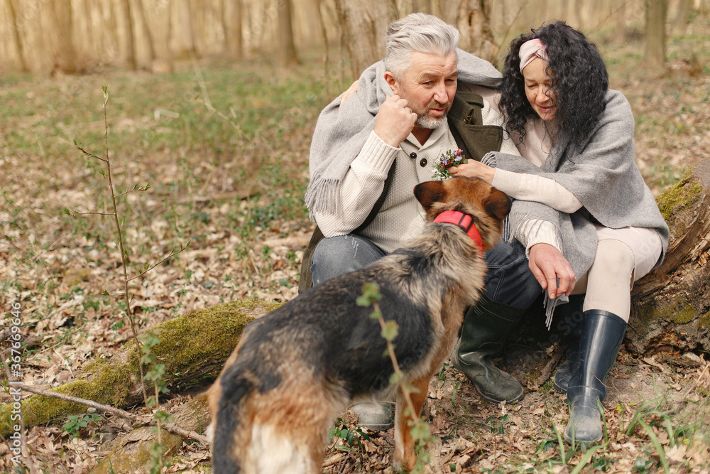 Seniors in a forest. People walks. Family with dog.